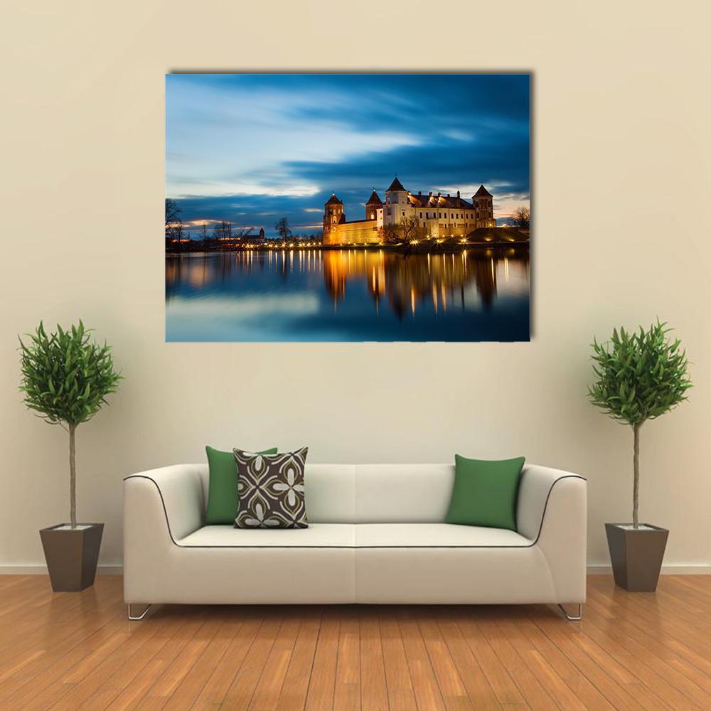 Mir Castle Reflection at Dusk Canvas Wall Art in orange, yellow and blue, single panel hung on a wall