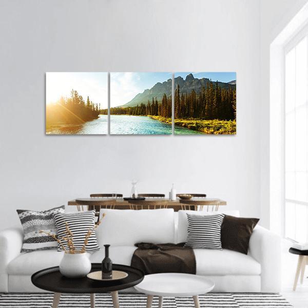 Castle Mountain at Golden Hour Over Turquoise River Panoramic Canvas Wall Art in yellow, green and blue, hung on a wall