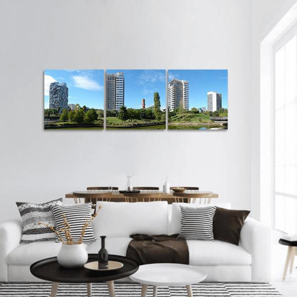 Catalonia Business District Under Blue Sky Panoramic Canvas Wall Art in white, green and blue, hung on a wall