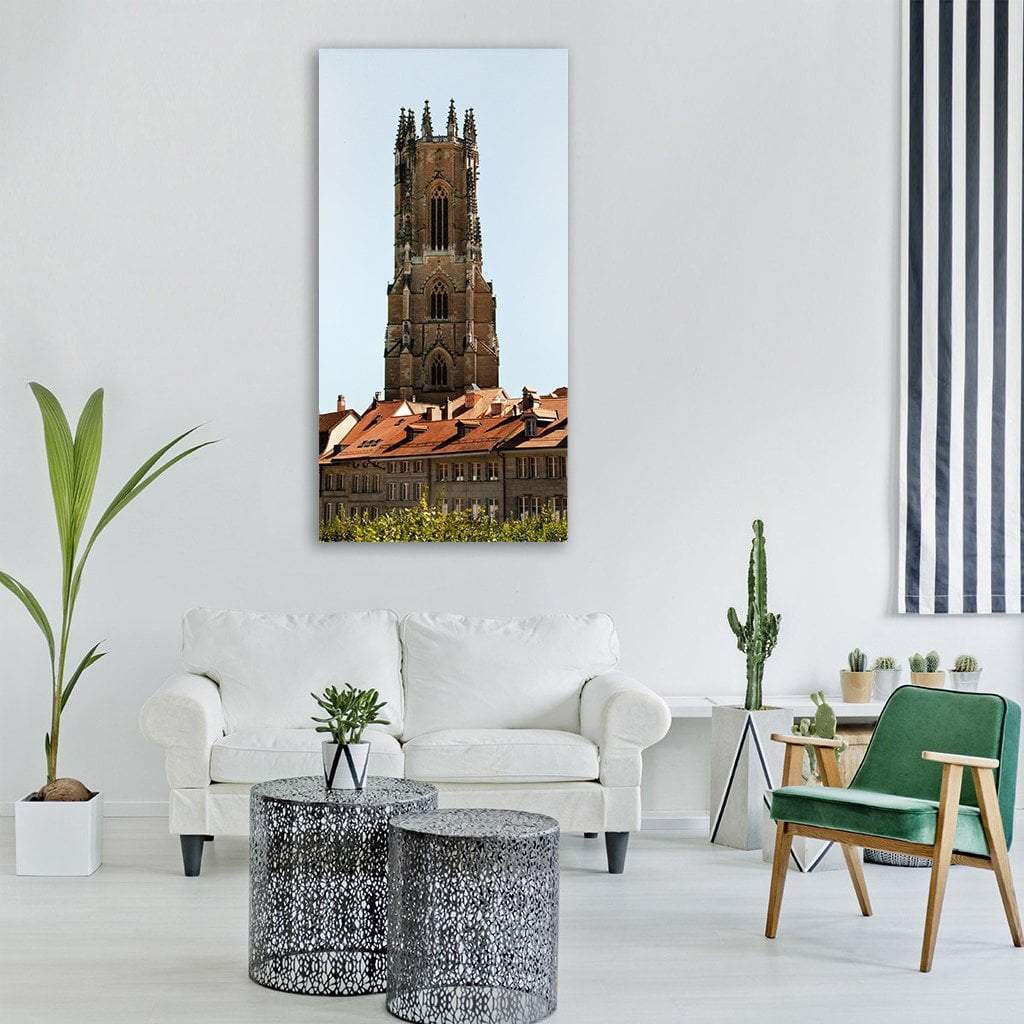 Gothic Cathedral Tower Over Terracotta Rooftops Vertical Canvas Wall Art in brown, orange and blue, single vertical panel hung on a wall