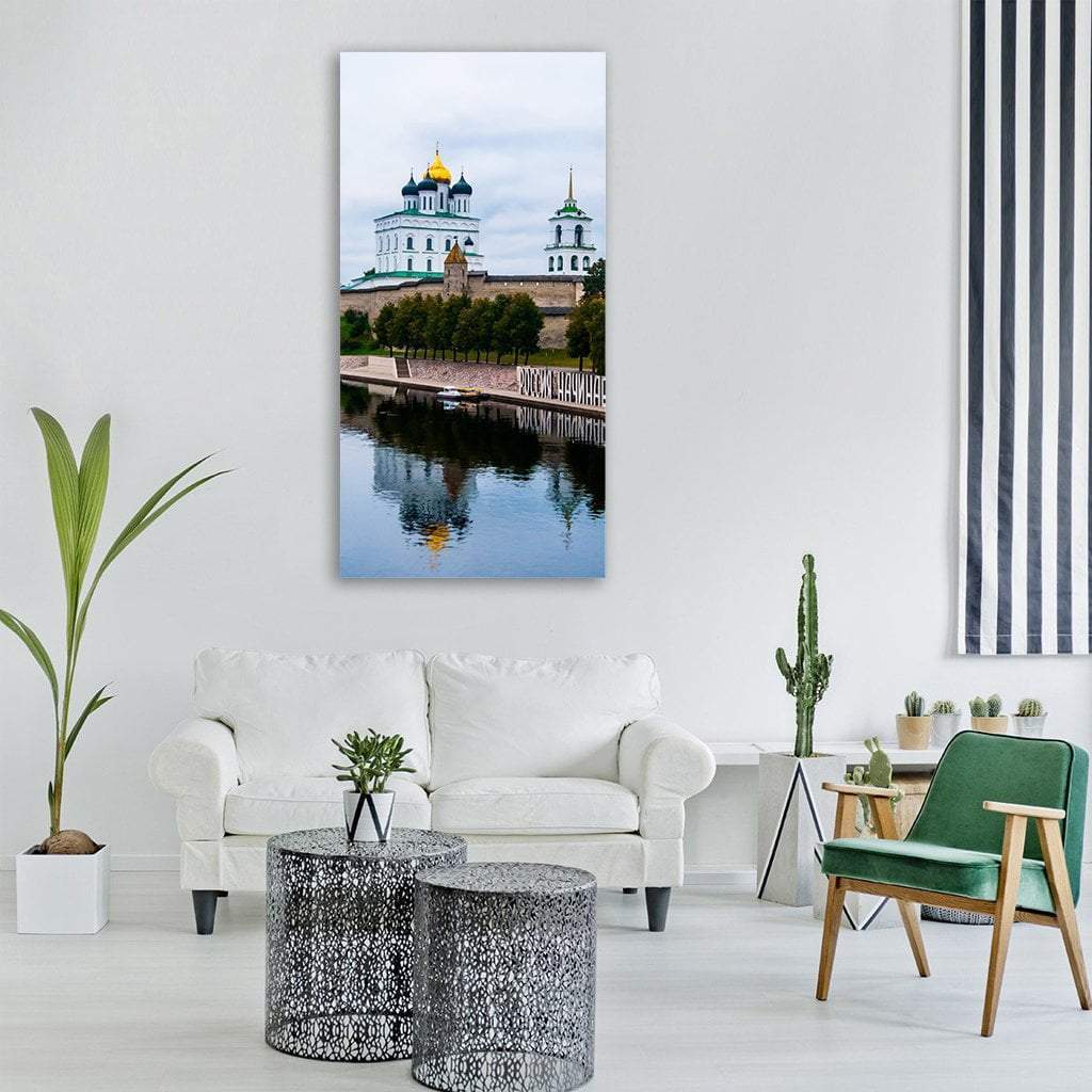 Pskov Krom Church and River Vertical Canvas Wall Art in white, green and blue, single vertical panel hung on a wall