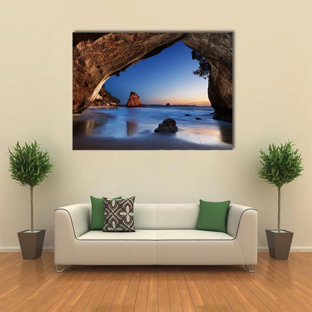 Serene Cave at Sunrise View Canvas Wall Art in brown, orange and blue, single panel hung on a wall