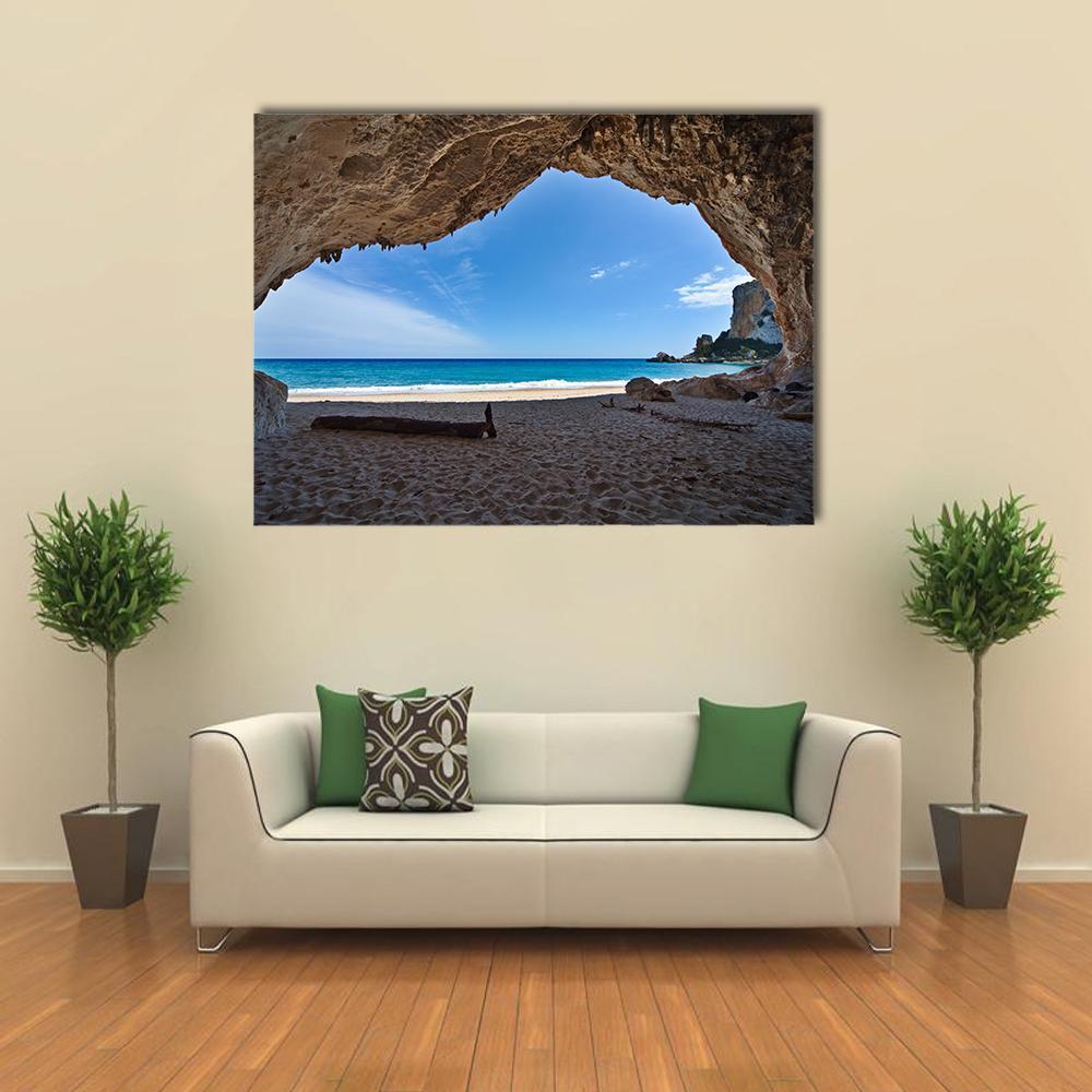 Serene Cave View Over Ocean Canvas Wall Art in beige, brown and blue, single panel hung on a wall