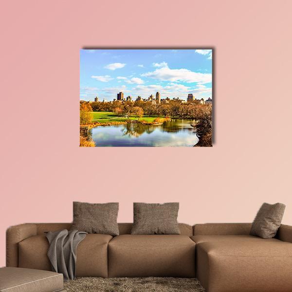 Central Park Autumn Reflection Canvas Wall Art in brown, yellow and blue, single panel hung on a wall