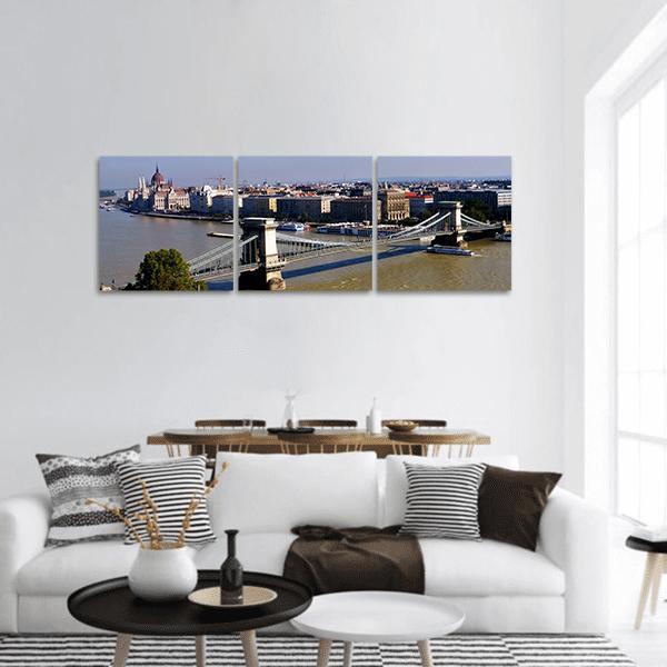 Chain Bridge and Budapest Skyline Panoramic Canvas Wall Art in gray, brown and blue, hung on a wall