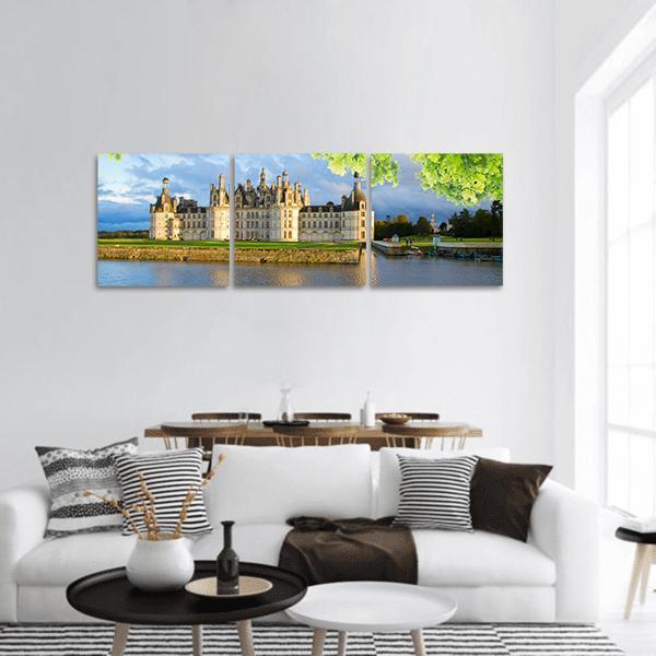 Chambord Castle with River Reflection Panoramic Canvas Wall Art in white, green and blue, hung on a wall