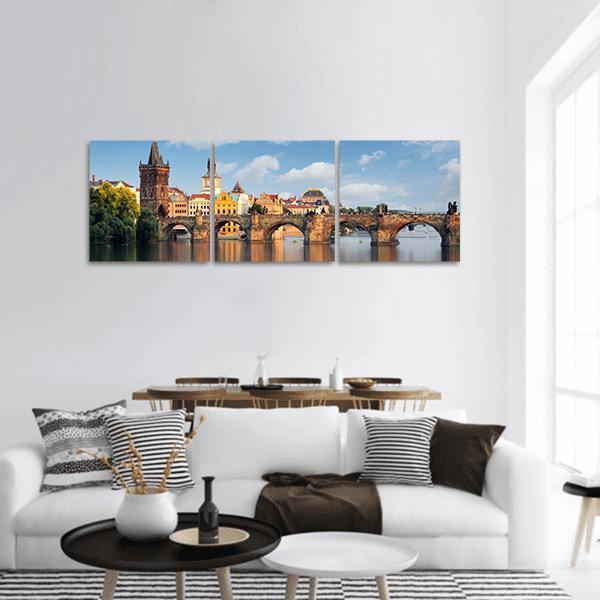 Charles Bridge in Prague Panoramic Canvas Wall Art in brown, orange and blue, hung on a wall