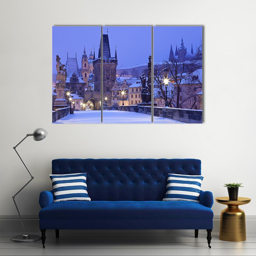 Charles Bridge at Night in Winter Canvas Wall Art in white, blue and purple, 3 panel horizontal set hung on a wall