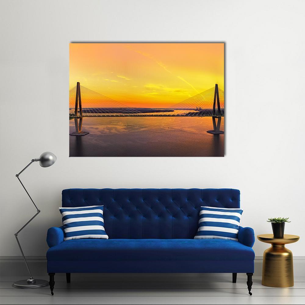 Charleston Bridge at Sunset Canvas Wall Art in orange, yellow and blue, single panel hung on a wall