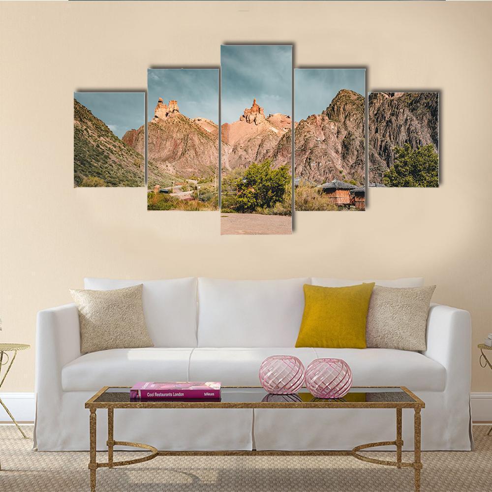 Charyn Canyon Rock Formations Canvas Wall Art in brown, orange and blue, 5 panel Star layout hung on a wall
