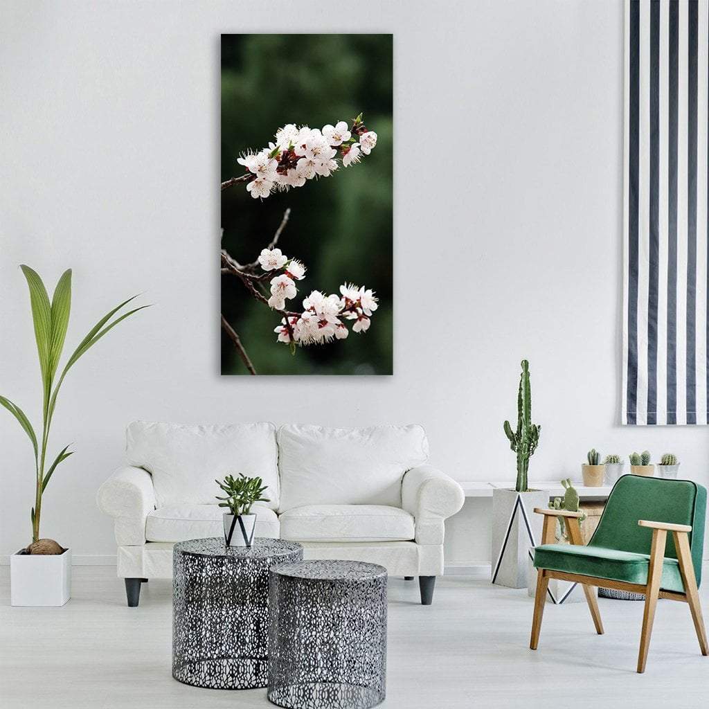 Cherry Blossom Branch on Dark Background Vertical Canvas Wall Art in white, green and pink, single vertical panel hung on a wall