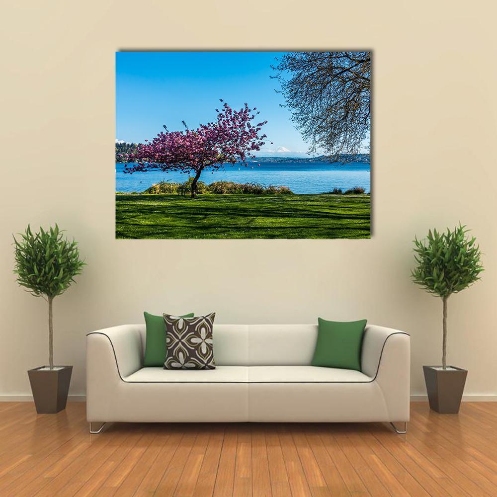 Cherry Tree by Mountain Lake Canvas Wall Art in green, blue and pink, single panel hung on a wall