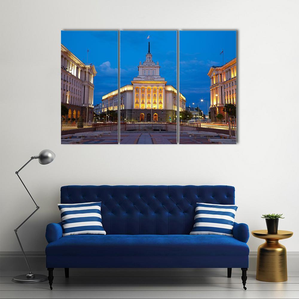 Sofia City Centre at Dusk Canvas Wall Art in gold, yellow and blue, 3 panel horizontal set hung on a wall