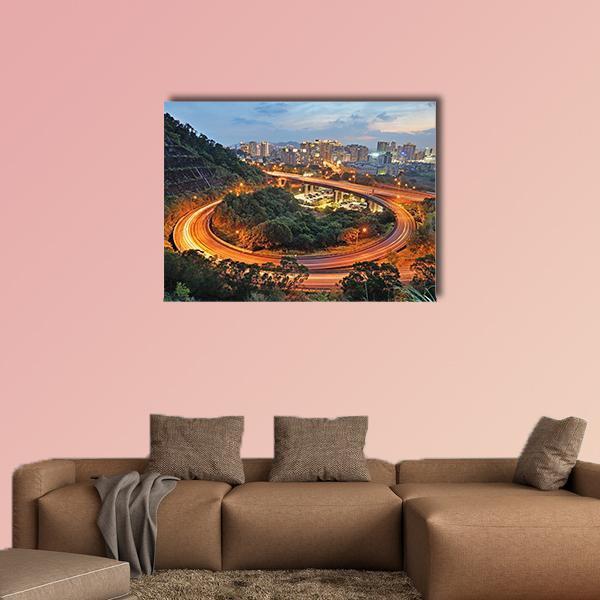 City Interchange at Night Canvas Wall Art in orange, green and blue, single panel hung on a wall