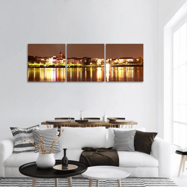 Golden Riverside City Skyline at Night Panoramic Canvas Wall Art in brown, gold and yellow, hung on a wall