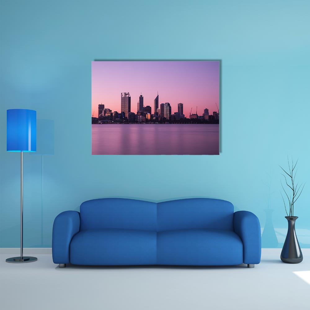 Purple Dusk City Skyline with Waterfront Reflections Canvas Wall Art in purple and pink, single panel hung on a wall