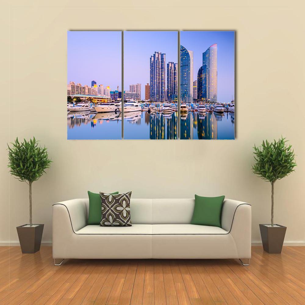 Busan Cityscape at Dusk Canvas Wall Art in gold, blue and purple, 3 panel horizontal set hung on a wall