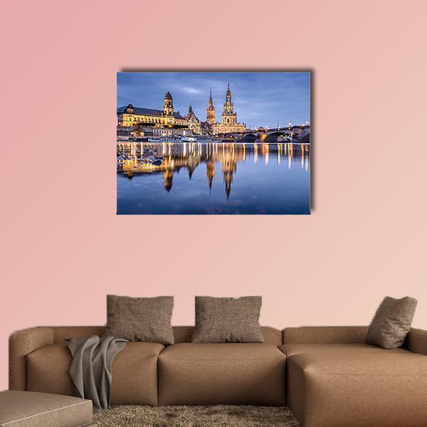 European City Skyline with Stone Bridge Reflection Canvas Wall Art in gold, yellow and blue, single panel hung on a wall
