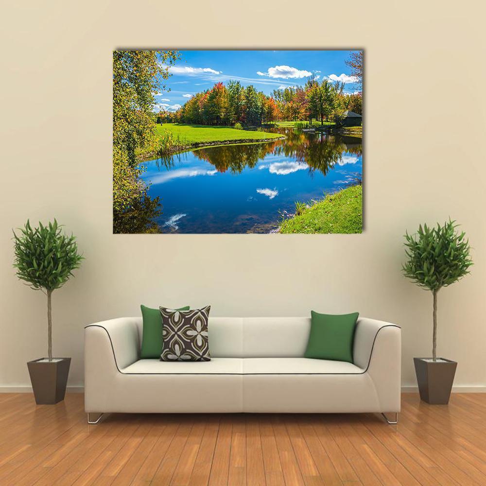 Autumn Lake Reflection with Wooden Dock Canvas Wall Art in orange, green and blue, single panel hung on a wall