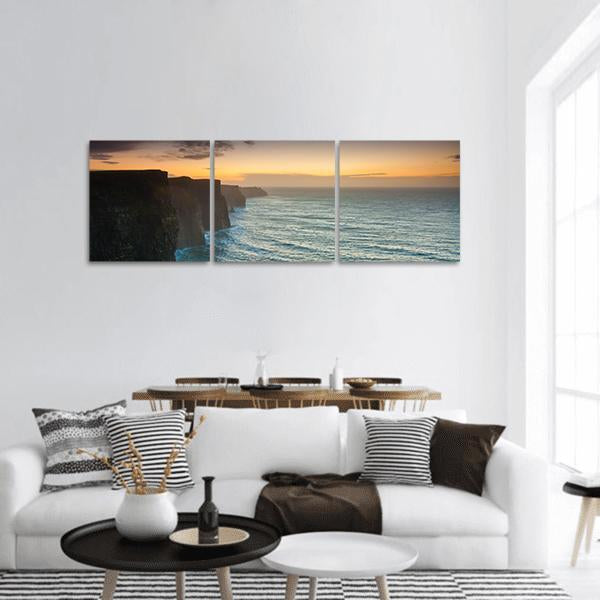 Cliffs of Moher at Golden Dusk Panoramic Canvas Wall Art in orange, yellow and blue, hung on a wall