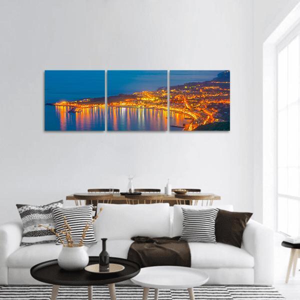 Coastal City Lights at Night Panoramic Canvas Wall Art in orange, yellow and blue, hung on a wall