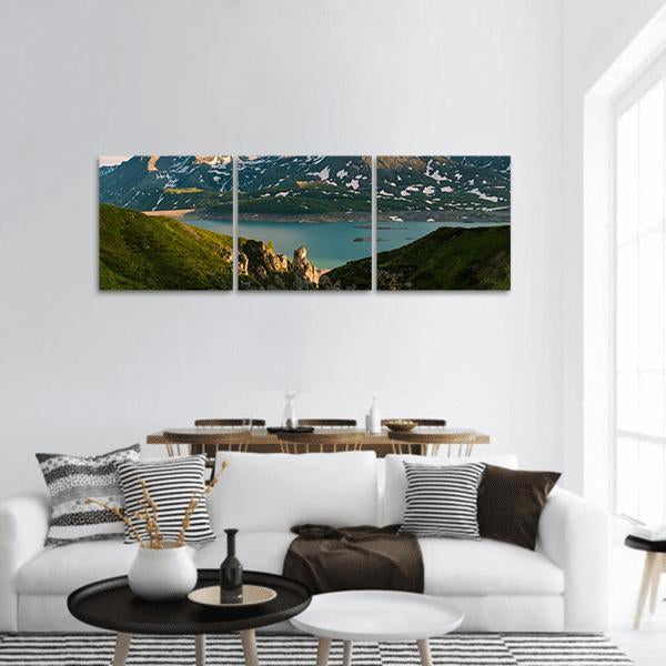 Snowcapped Peaks Over Turquoise Lake Panoramic Canvas Wall Art in white, green and blue, hung on a wall