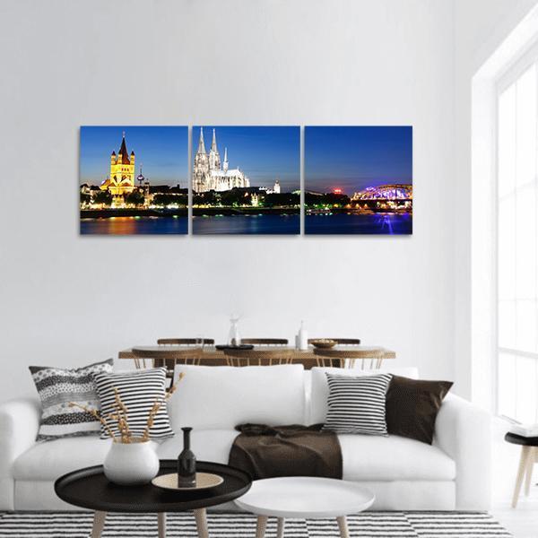 Cologne City at Night Panoramic Canvas Wall Art in black, yellow and blue, hung on a wall