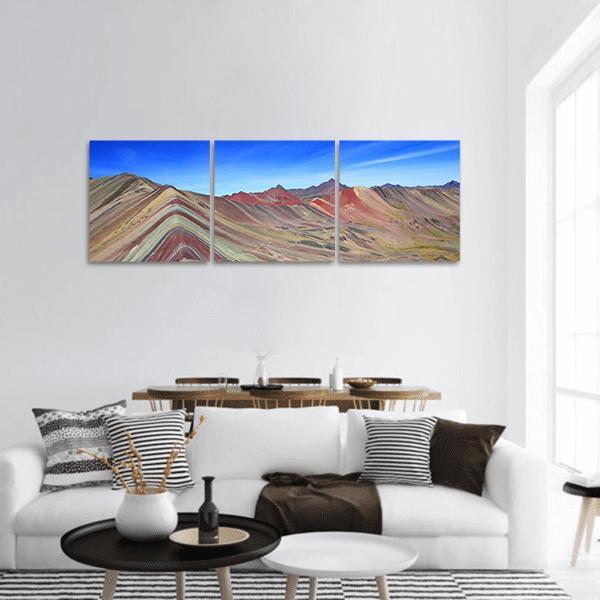 Rainbow Mountain in Peru Panoramic Canvas Wall Art in brown, blue and multicolor, hung on a wall
