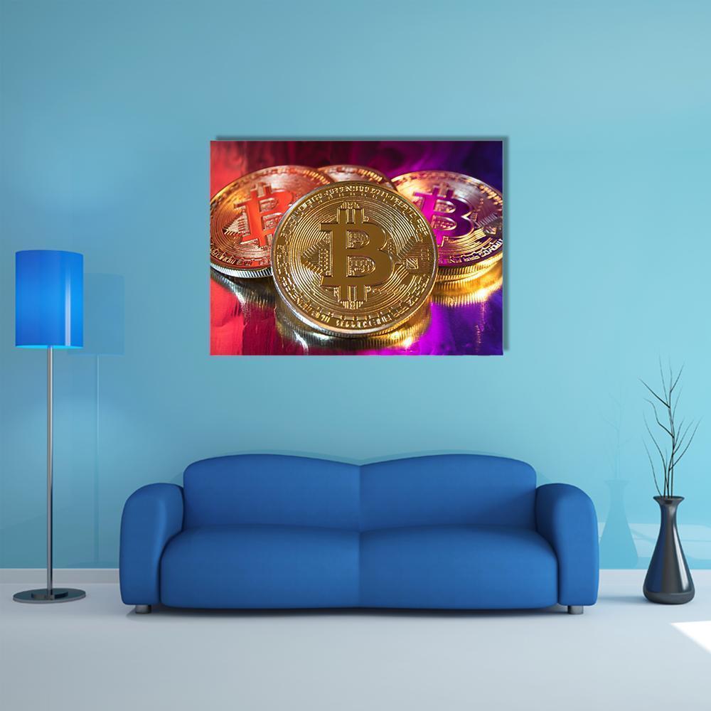 Three Gold-colored Bitcoin Coins Canvas Wall Art in gold, red and purple, single panel hung on a wall