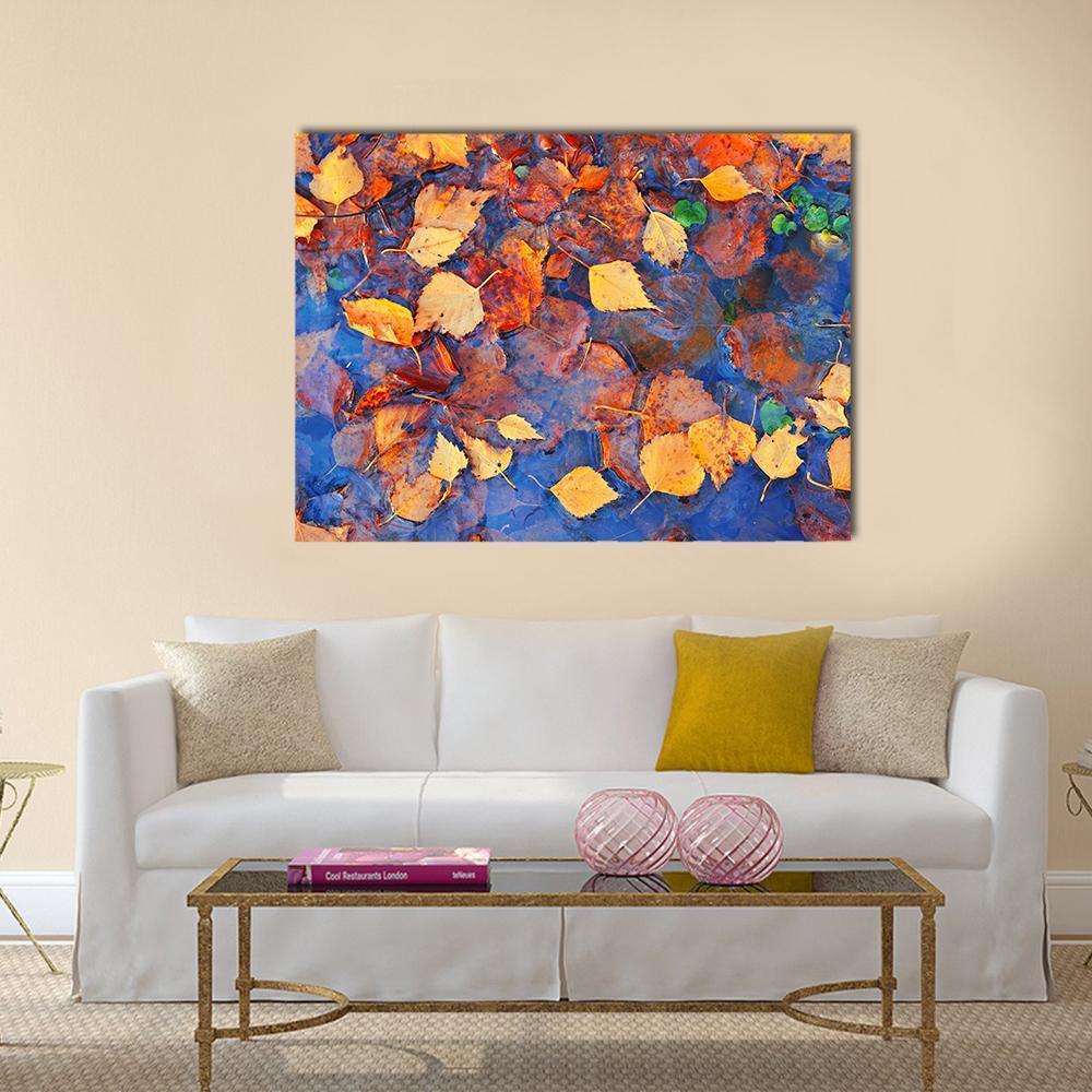 Autumn Birch Leaves on Icy Pond Canvas Wall Art in orange, yellow and blue, single panel hung on a wall