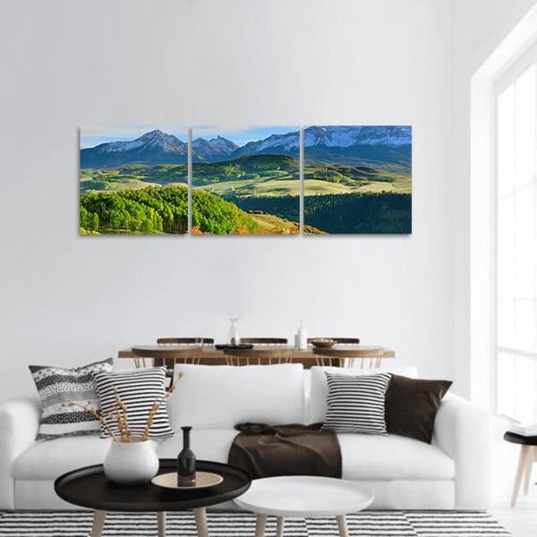 Colorado Mountain Valley with Snow-capped Peaks Panoramic Canvas Wall Art in green and blue, hung on a wall