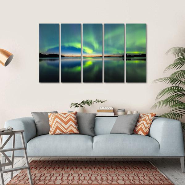 Northern Lights Over Still Lake Canvas Wall Art in black, green and blue, hung on a wall
