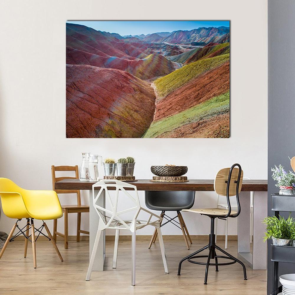 Colorful Rainbow Mountains Canvas Wall Art in red, green and multicolor, single panel hung on a wall