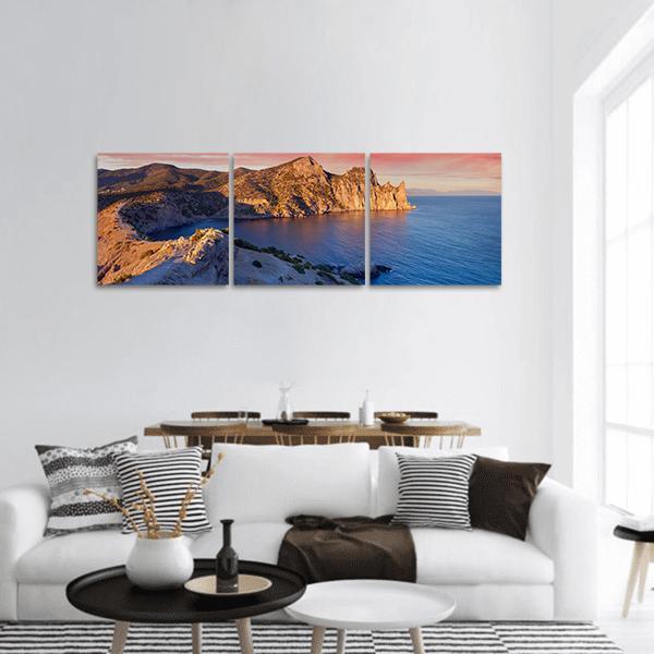 Summer Sunrise Over Coastal Cliffs Panoramic Canvas Wall Art in brown, orange and blue, hung on a wall