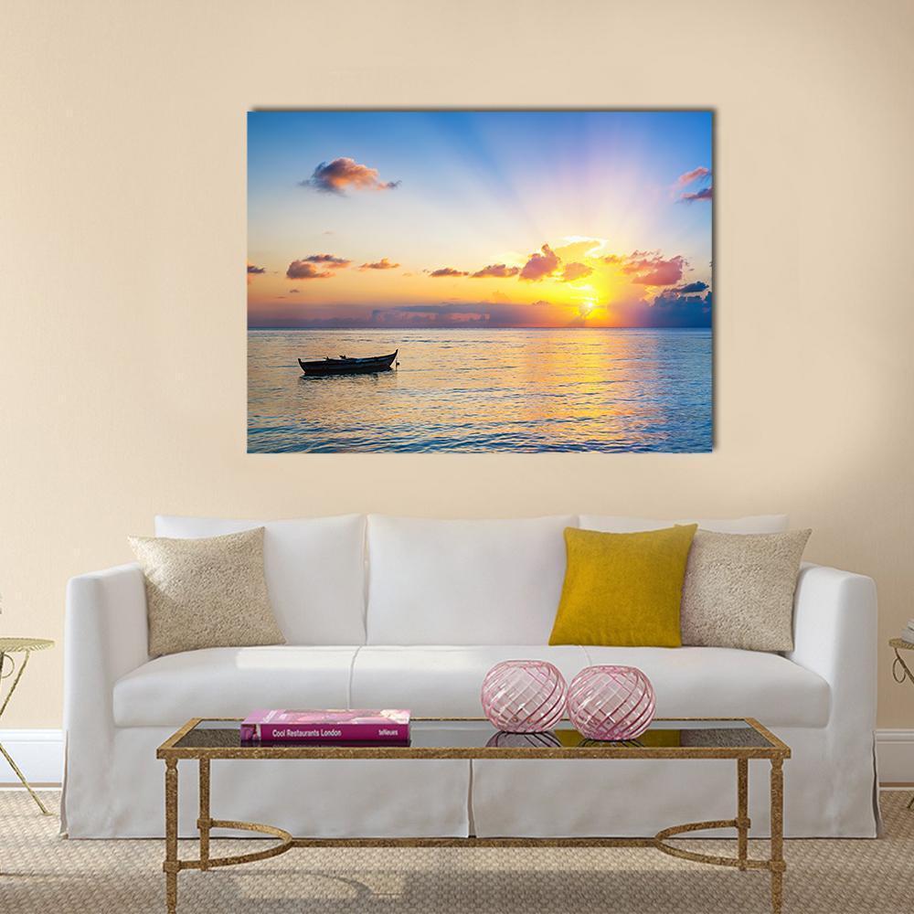 Colorful Sunrise Over Ocean Canvas Wall Art in orange, yellow and blue, single panel hung on a wall