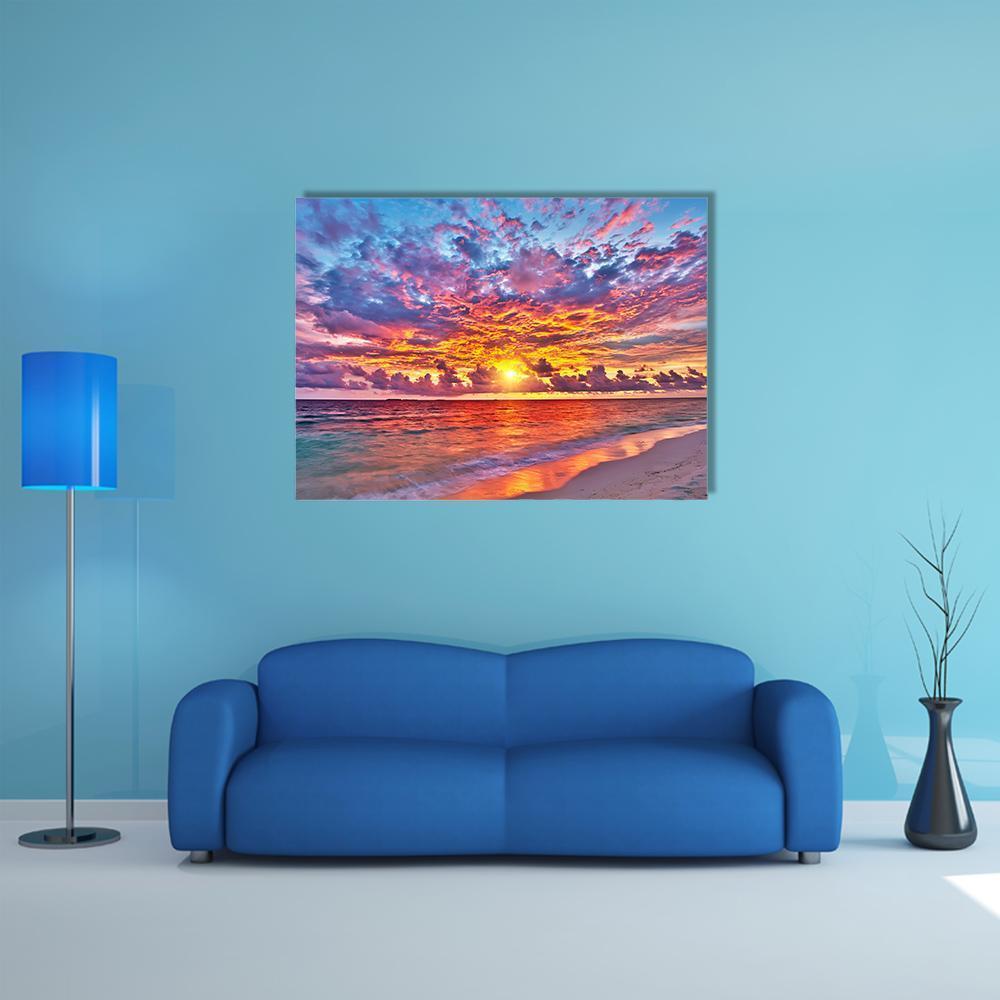 Colorful Sunset Over the Ocean Canvas Wall Art in orange, blue and pink, single panel hung on a wall