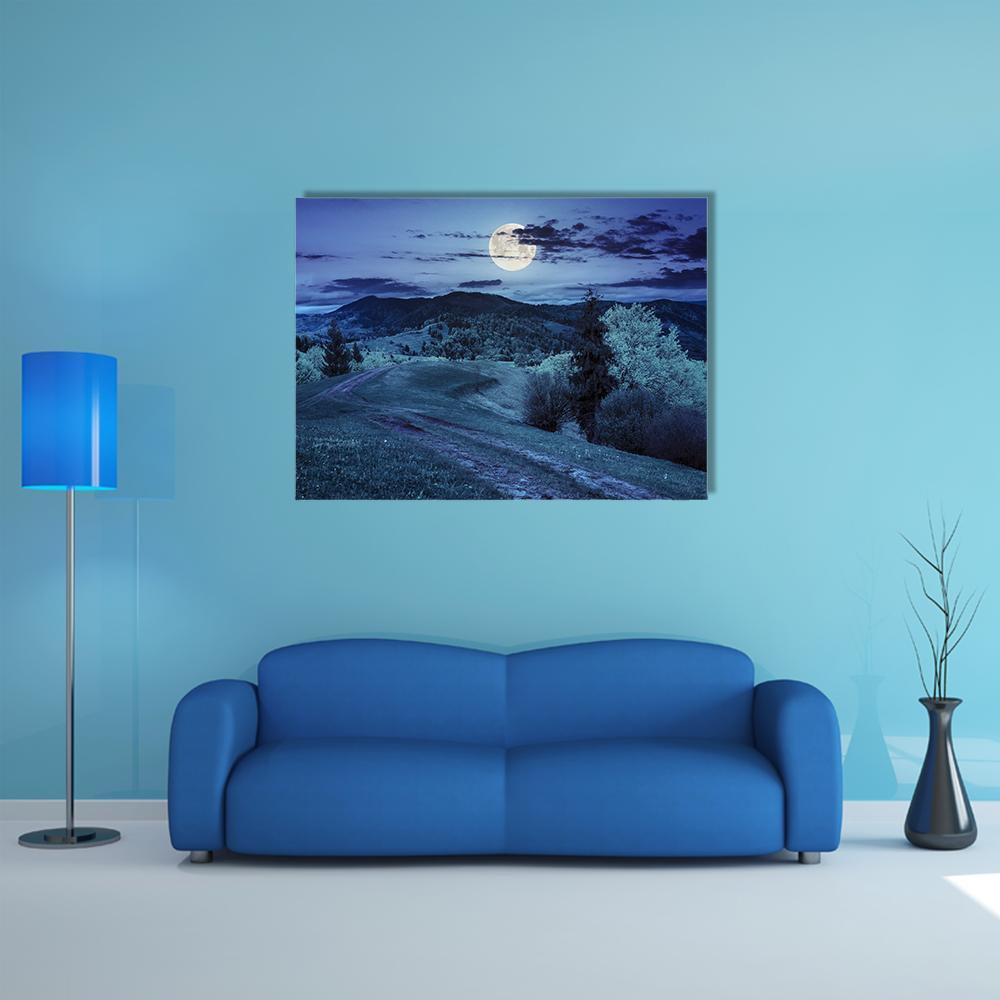 Moonlit Mountain Road Through Forest Canvas Wall Art in gray, blue and navy, single panel hung on a wall