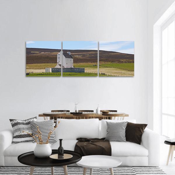 Corgarth Castle on Heather Moorland Panoramic Canvas Wall Art in brown, green and blue, hung on a wall