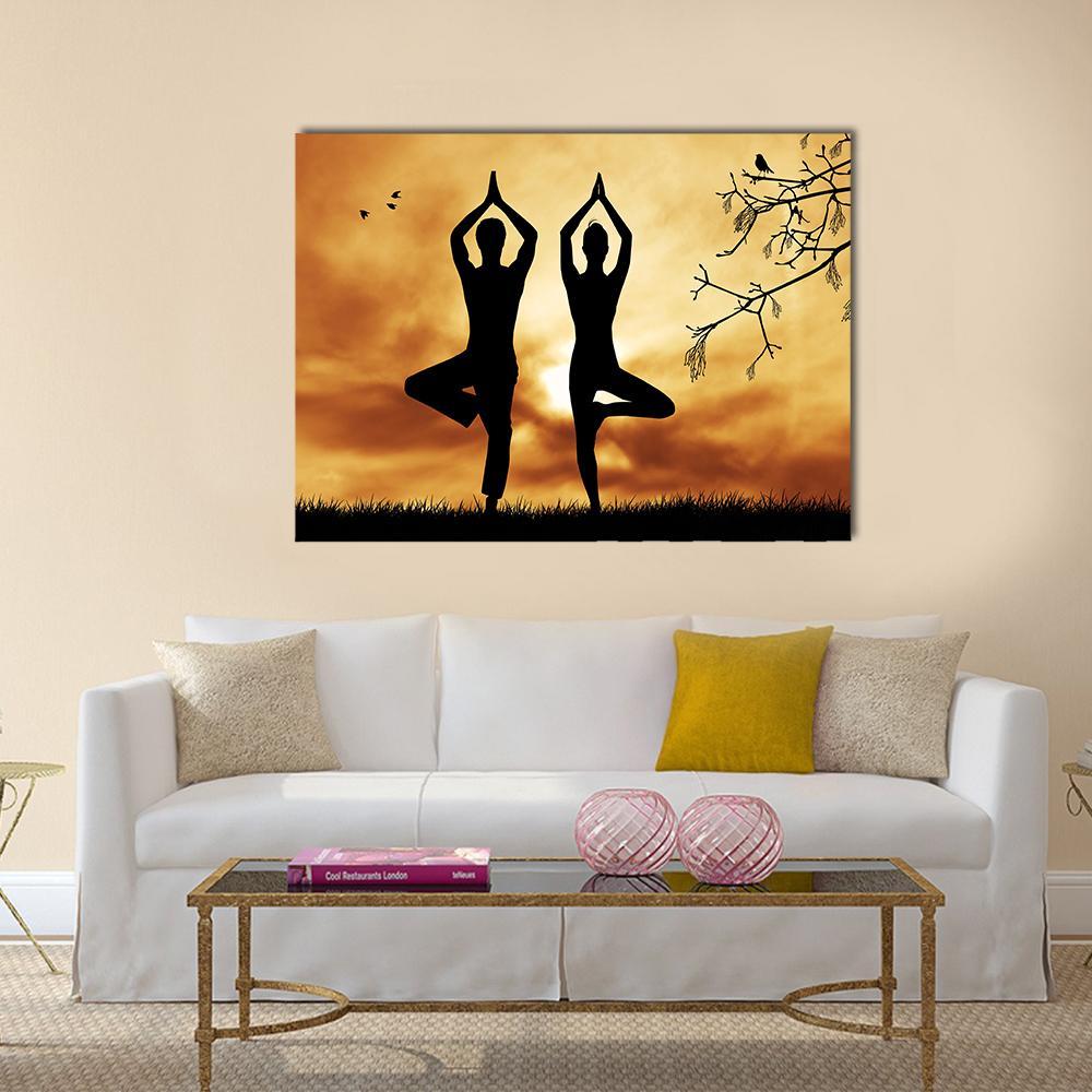 Mirrored Yoga Tree Silhouttes at Sunset Canvas Wall Art in black, orange and yellow, single panel hung on a wall