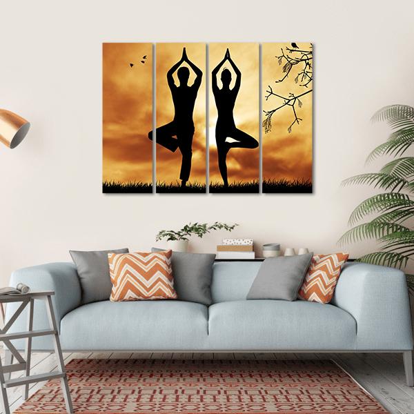 Mirrored Yoga Tree Silhouttes at Sunset Canvas Wall Art in black, orange and yellow, hung on a wall