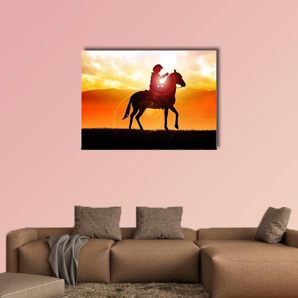 Cowboy and Horse Silhouette at Sunset Canvas Wall Art in black, orange and yellow, single panel hung on a wall