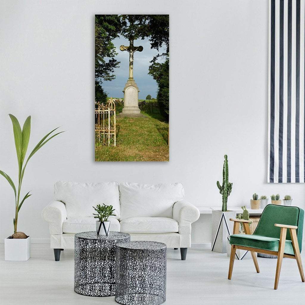 Stone Crucifix Beside White Wrought Iron Gate Vertical Canvas Wall Art in white, gray and green, single vertical panel hung on a wall
