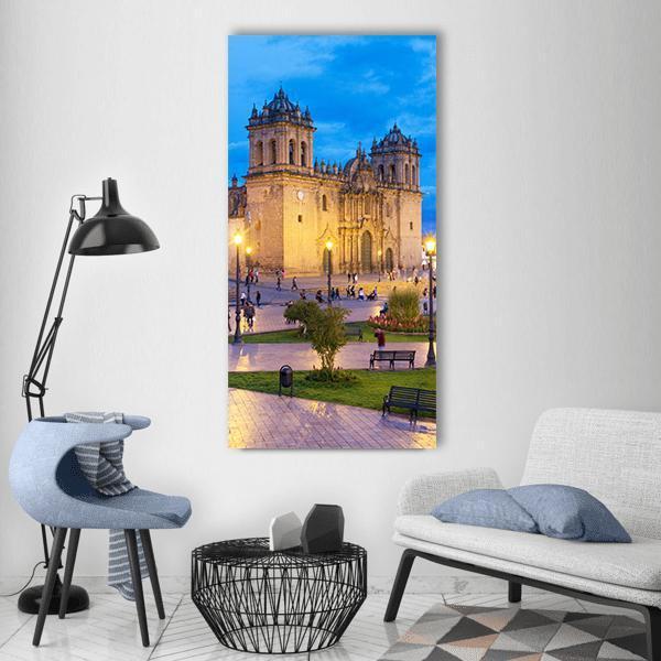 Cusco Cathedral Plaza at Twilight Vertical Canvas Wall Art in beige, yellow and blue, single vertical panel hung on a wall