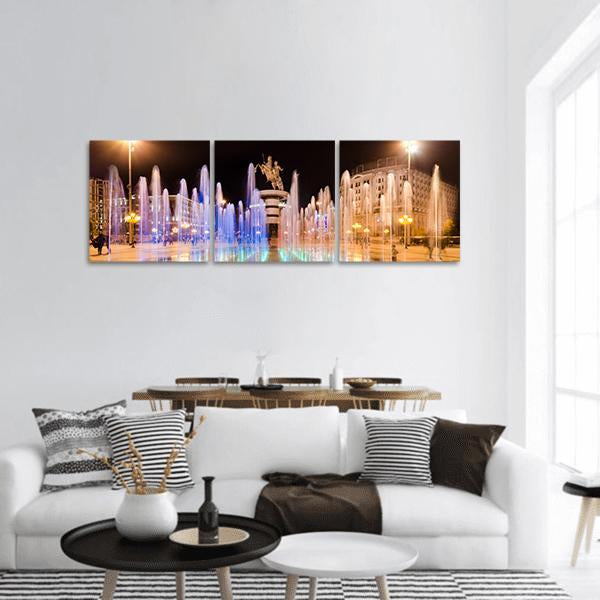 Skopje Square Fountains at Night Panoramic Canvas Wall Art in black, yellow and blue, hung on a wall