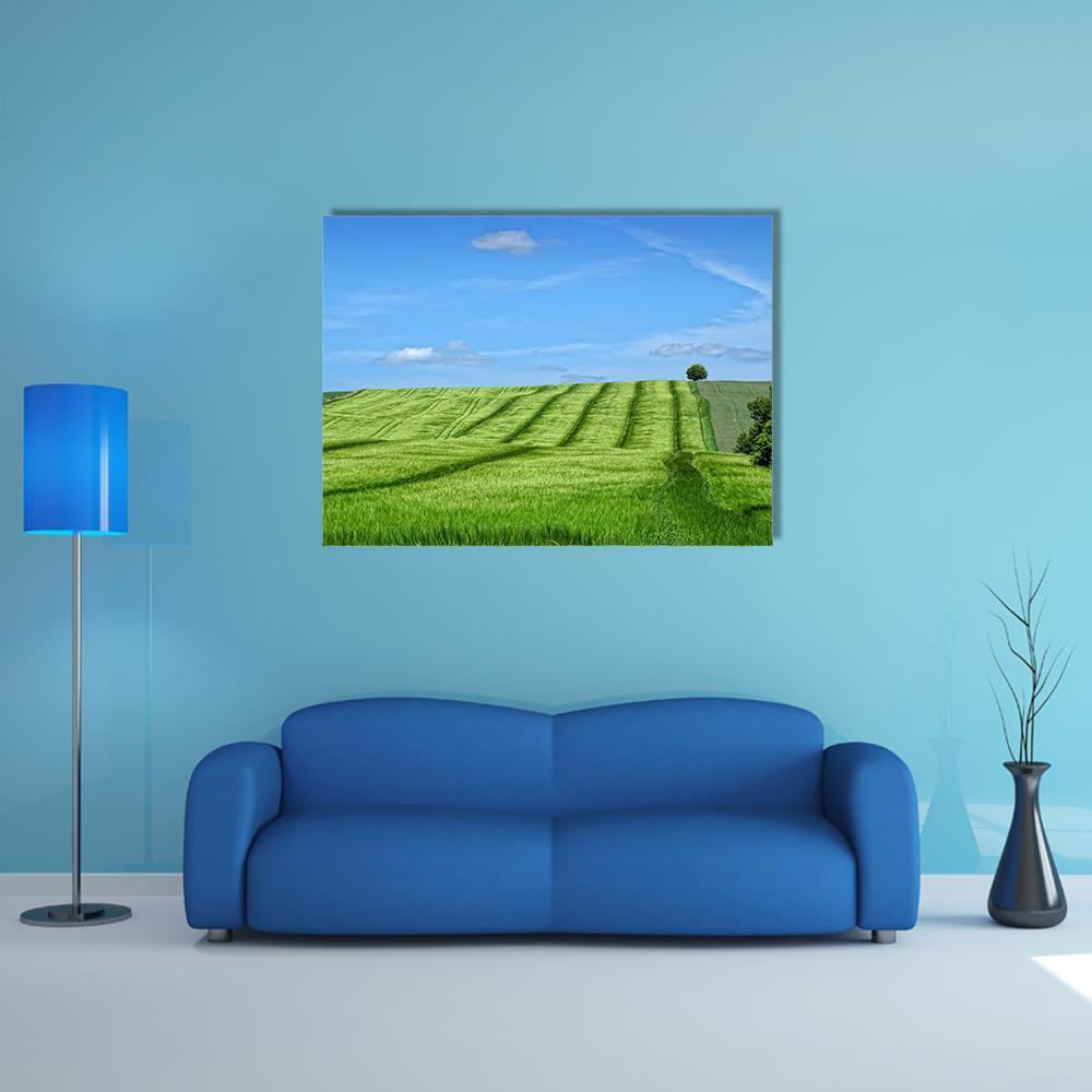 Danish Countryside Landscape Canvas Wall Art in green and blue, single panel hung on a wall