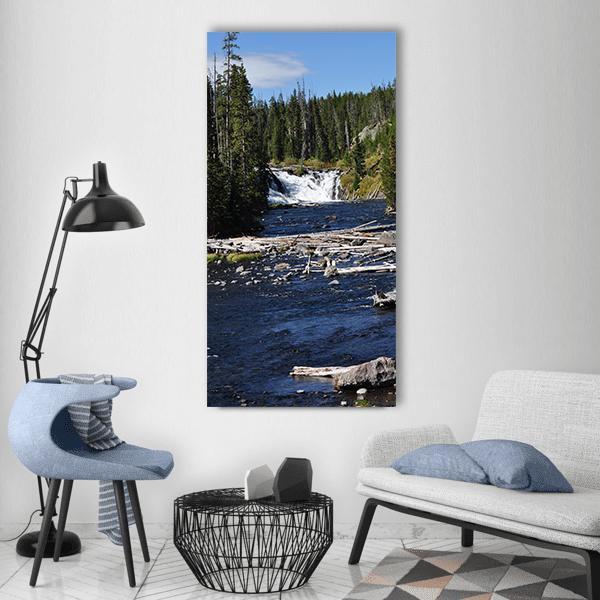 Yellowstone Waterfall with Fallen Logs Vertical Canvas Wall Art in brown, green and blue, single vertical panel hung on a wall