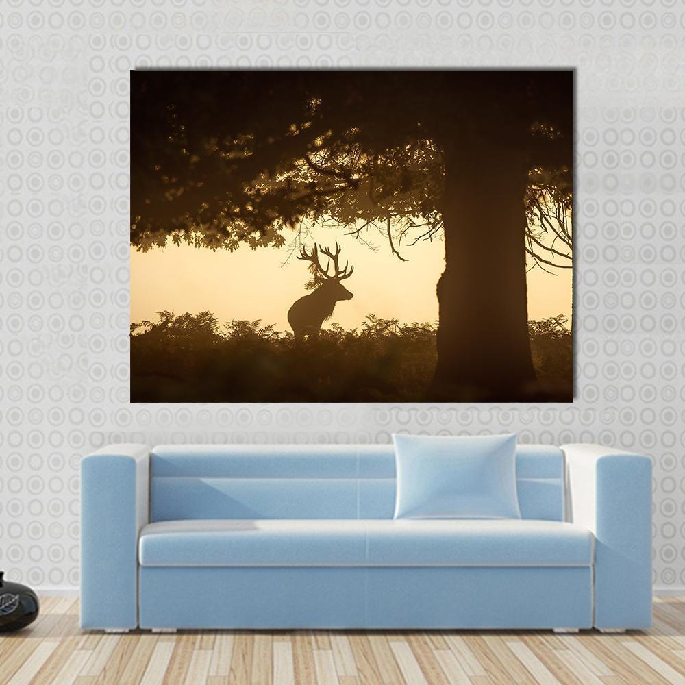 Golden Hour Stag Silhouette Canvas Wall Art in black, orange and yellow, single panel hung on a wall