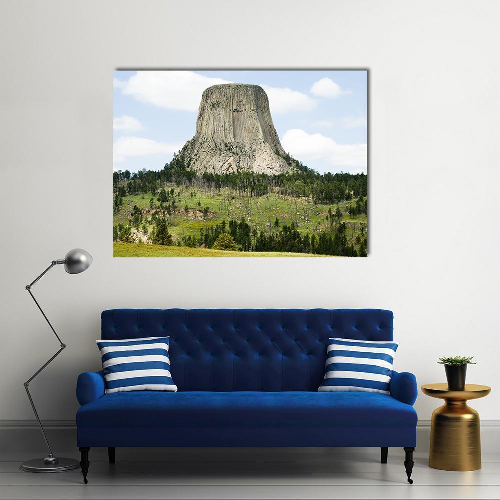 Devils Tower in Pine Forest Canvas Wall Art in gray, green and blue, single panel hung on a wall