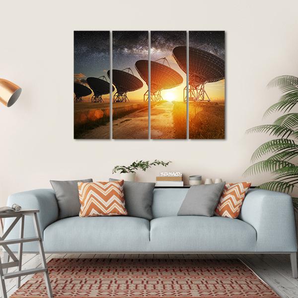 Radio Telescope Array Under the Milky Way Canvas Wall Art in black, orange and yellow, hung on a wall