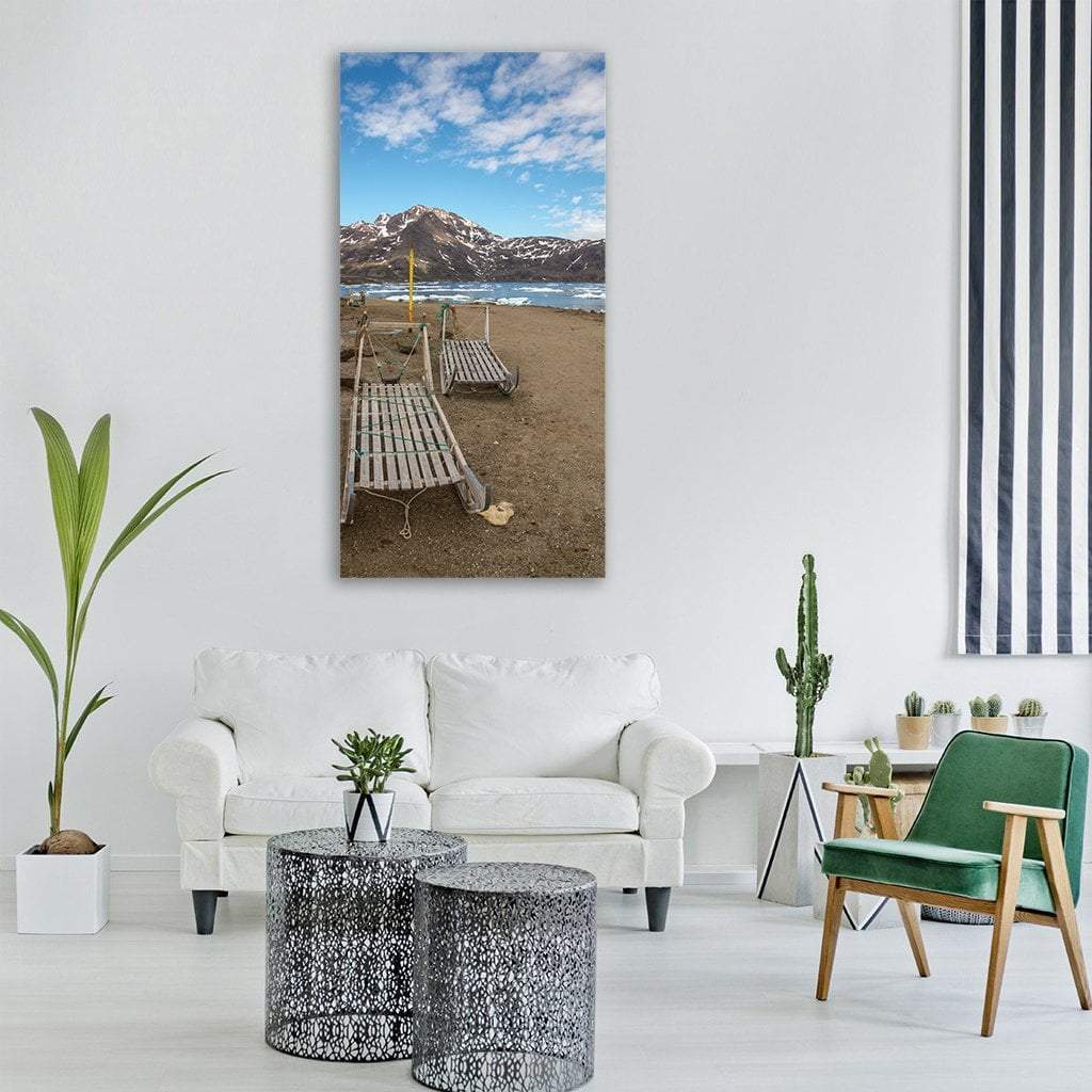 Wooden Dog Sleds on Snowy Shoreline Vertical Canvas Wall Art in white, brown and blue, single vertical panel hung on a wall